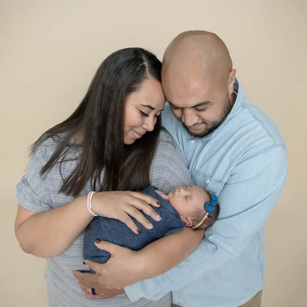 newborn baby held by mom and dad by utah county photographer